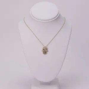 Gold necklace with Hamsa pendant on display.