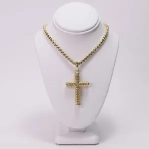 Gold cross necklace on display stand.