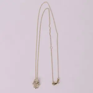 Gold necklace with Hamsa hand pendant.