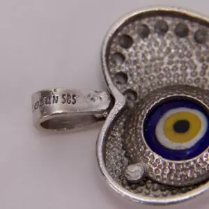 Silver pendant with evil eye design.
