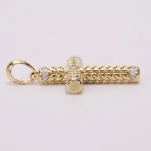 Gold cross pendant with intricate design.