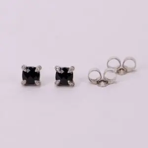 Black stud earrings with silver settings.