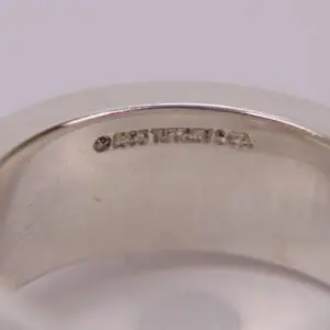 Silver ring with engraved text inside.