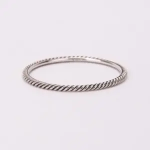 Twisted silver bangle on white background.