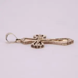 Gold cross pendant on white background.