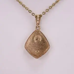Gold pendant with chain on display.