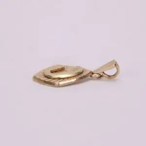 Golden pendant with loop on light background.