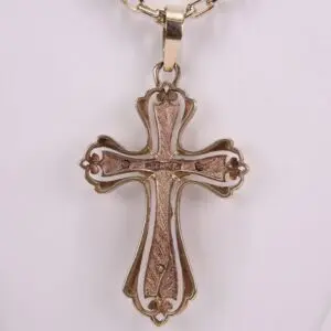 Ornate gold cross pendant on chain.