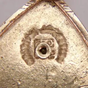 Gold-plated surface with central circular indentation.