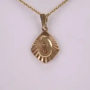 Gold pendant with engraved figure on chain.
