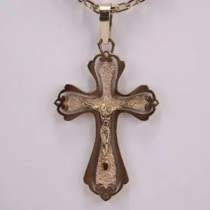 Ornate gold cross pendant on chain.