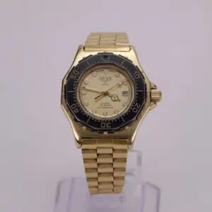 Gold wristwatch with black bezel on display.