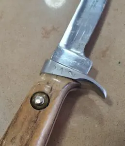 Knife with wooden handle on surface.