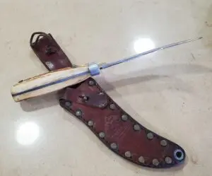 Bone-handled knife with brown leather sheath.