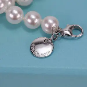 Pearl necklace with silver tag and clasp.