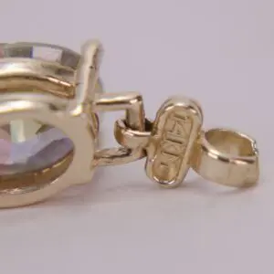 Gold pendant with a colorful gemstone.