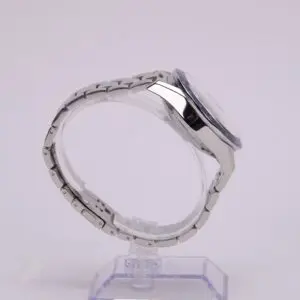 Silver wristwatch on clear display stand.
