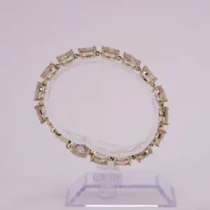 Gold bracelet with rectangular pink gemstones.