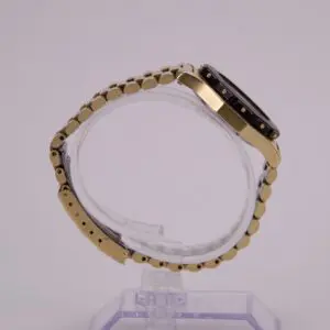 Gold wristwatch displayed on a clear stand.