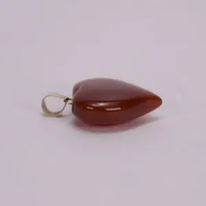 Red heart-shaped pendant on a plain background.