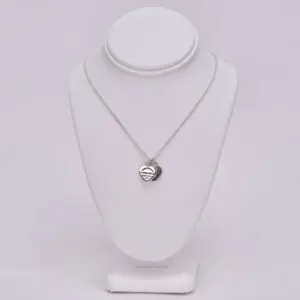 Heart pendant necklace on white display stand.