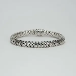 Silver braided bracelet on white background.