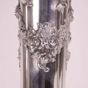 Ornate silver vase with floral design.