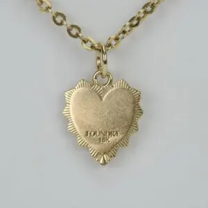 Gold heart-shaped pendant on chain necklace.