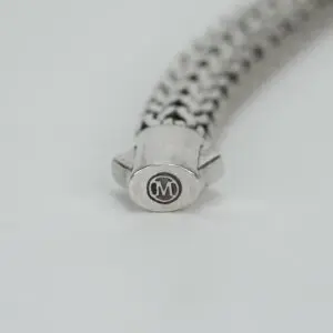 Silver bracelet clasp with engraved "M" logo.