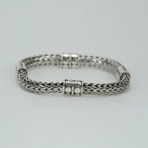 Silver woven bracelet on white background.