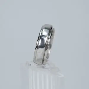 Silver ring displayed on clear stand.