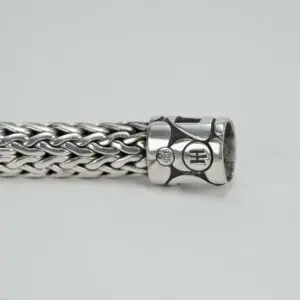 Silver woven bracelet with decorative clasp.