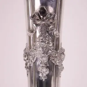 Ornate silver vase with floral details.