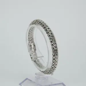 Silver woven bracelet on display stand.