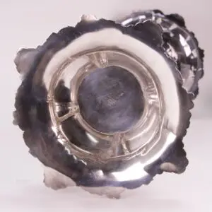 Bottom view of a silver ornate candleholder.