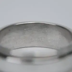 Close-up of silver ring with engravings.