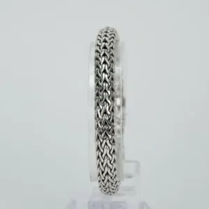 Silver chain bracelet on a clear stand.