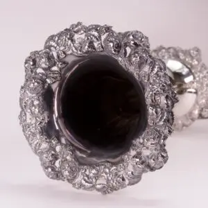 Intricate silver goblet with ornate floral design.
