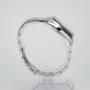Silver wristwatch on a clear stand.