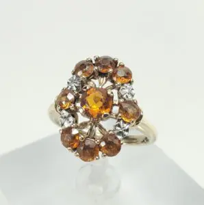 Gold ring with orange gemstones and diamonds.