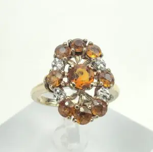 Gold ring with orange gemstones and diamonds.