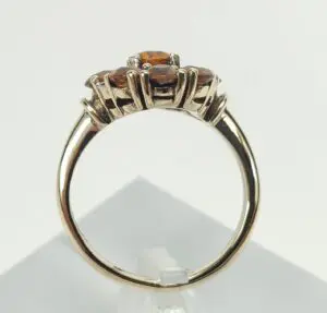 Gold ring with orange gemstone accents.