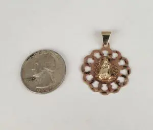 Quarter and decorative gold pendant side by side.