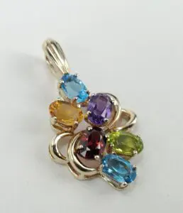 Gold pendant with colorful gemstones.