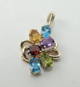 Gold pendant with colorful gemstones cluster.