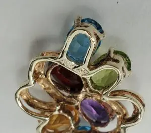 Colorful gemstone pendant with intricate metal design.