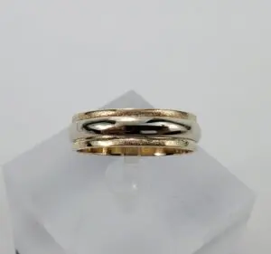 Gold wedding band on display stand.
