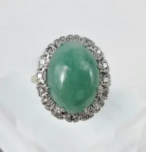 Green gemstone ring with diamond accents.