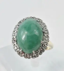 Green gemstone ring with diamond accents.