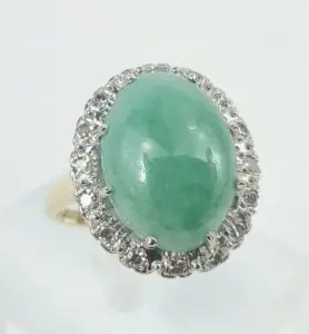 Gold ring with green gemstone and diamonds.